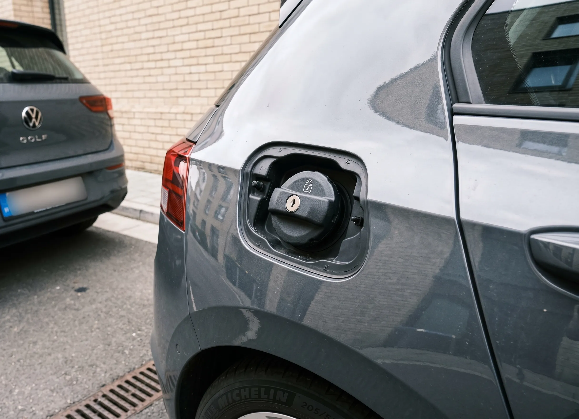 protection du réservoir avec bouchon à clé et voiture stationnée contre un mur éclairé